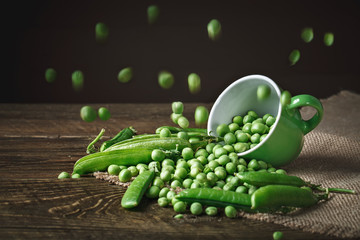 Delicious ripe green peas lying on a wooden table.