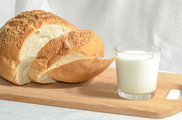 Homemade bread, sliced on a wooden board with milk