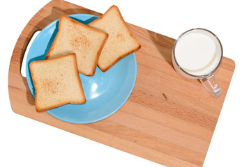 Square toast on a blue plate on a wooden board and a mug of milk