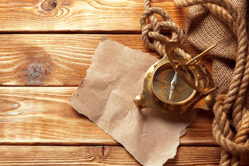 compass and rope on old wooden boards