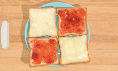 Square toast with jam on a blue plate on a wooden board and a mug of milk