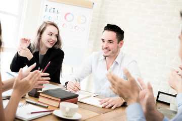 Business people clapping hands to congratulate  their colleague at the meeting