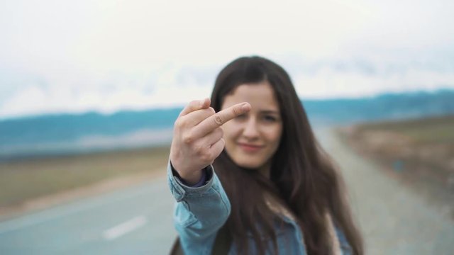 Attractive Caucasian brunette girl is being wild and bad, showing a middle finger gesture to you. Sends his work to the devil and goes on leave. Hates his boss or his boyfriend.