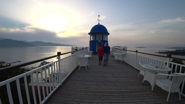 Mum and the son walk on a coast of the tropical sea