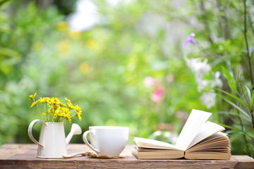 Notebook with yellow flower and cup on wooden table