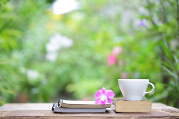 Notebook with flower and cup on wooden table