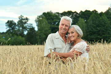 Naklejka na ściany i meble Senior couple on field of wheat 