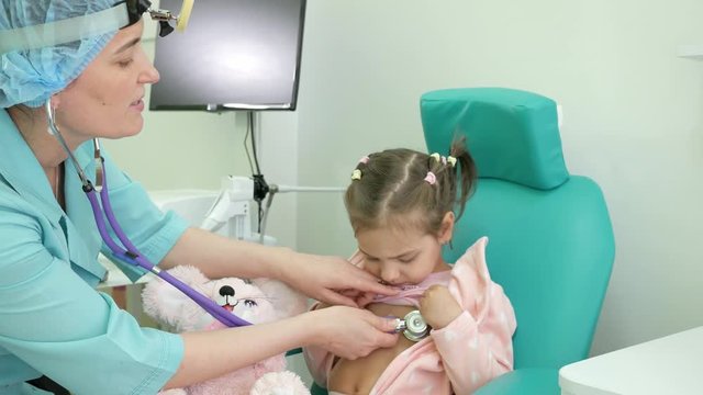 Happy child at doctor's reception, consultation of ENT doctor, otoscopy, advice otolaryngologist in clinic, treatment of ENT diseases in children, Medical procedure, otolaryngologist treats infant