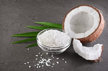 Healthy food. Fresh coconut with flakes in glass plate and green palm leaves