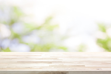 Wood table top on blur white green natural abstract background from tree branches