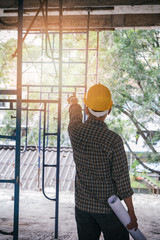 Engineer with blueprint in building construction site