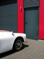 Seltener weißer englischer Roadster und Sportwagen der Fünfzigerjahre mit Chromspeichenrad beim...