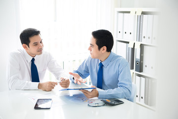 Businessmen discussing financial documents in the office