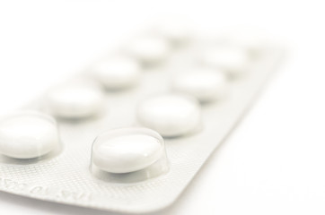 Contraceptive tablets in packages and without on a light background.