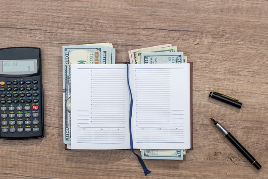 empty notepad, pen, doolar and coin on desk