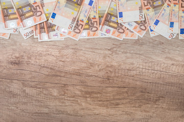 Fototapeta na wymiar many 50 euro banknotes on wooden desk. copyspace