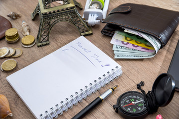 travel concept - empty notebook with pencil, euro and dollar in wallet, compass, seashell, phone, eiffel tower.
