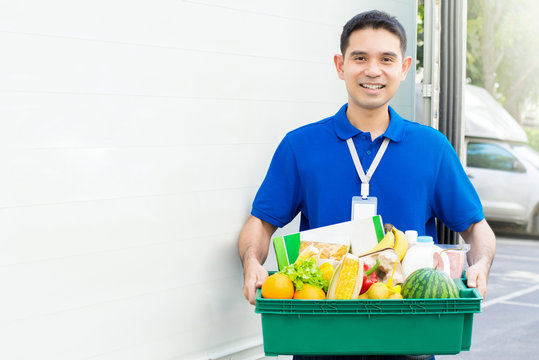 Asian Delivery Man Carrying Food Basket Beside The Car