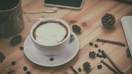 cup of coffee on old wooden desk. Simple workspace or coffee break in morning/ selective focus