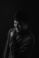 Young asian man's portrait against black background