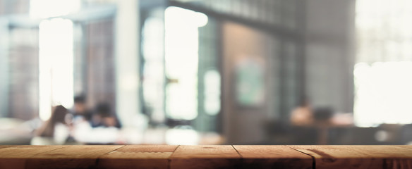 Wood table top on blur restaurant (cafe) interior background