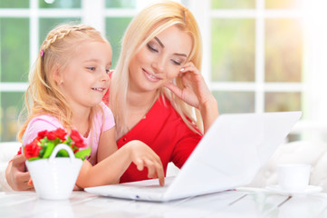 woman and little girl using   laptop