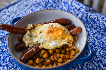 Moroccan spicy chickpeas with sausages and fried eggs.