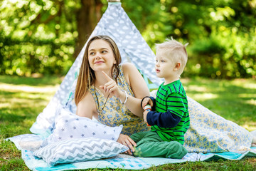 Happy mother and little son in the park. The concept of lifestyle and childhood.