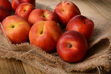 Fototapeta na wymiar Pile of nectarine peaches on wooden table - closeup