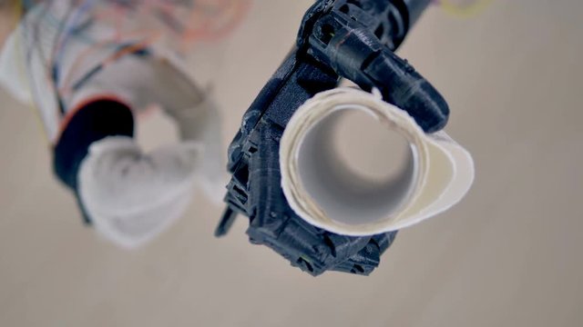 Paper towels being lifted by bionic arm. 4K.