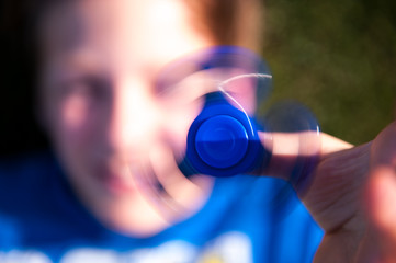 young boy with a blue fidget spinner