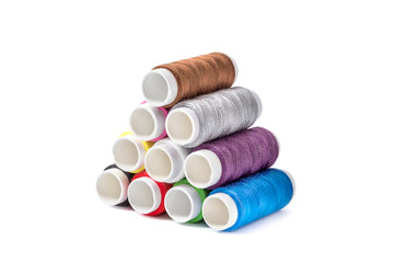 Stack of colorful sewing threads on white background.
