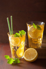 ice tea with lemon and mint on dark rustic background