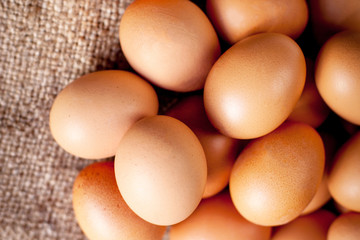  Heap of fresh brown Eggs on wooden  background closeup