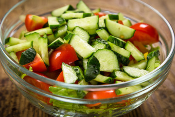 Salad with plenty of cut vegetables on glass bowl