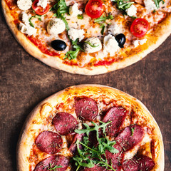 Pizza with salami, olives and cheese on a rustic wooden table flat lay photo