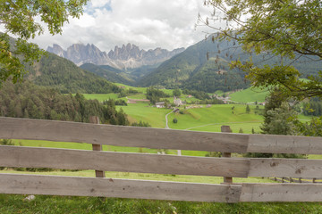 Fototapeta na wymiar Wooden fence next to an Italian mountain pasture in St. Magdalena in Val di Funes