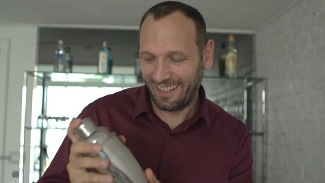 Happy male barman preparing cocktail in bar, super slow motion 240fps