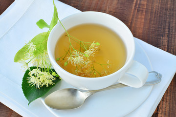 Cup of linden tea over wooden table