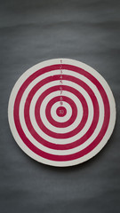 Old dart board on grey paper background