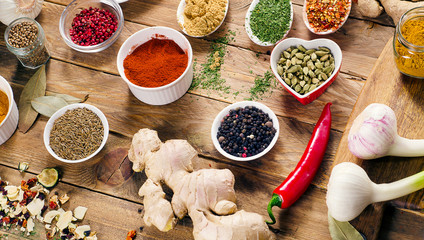 Colorful spices and fresh herbs on wooden table