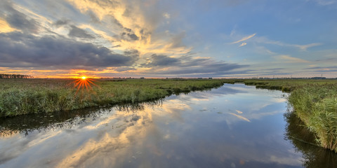 Fototapeta na wymiar Sunset over river in marshland nature reserve