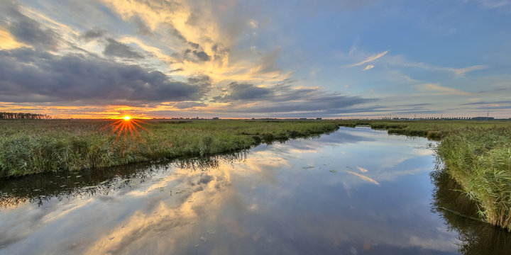 Sunset over river in  marshland nature reserve