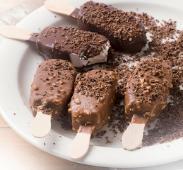Chocolate ice cream popsicles on white plate
