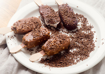 Chocolate ice cream popsicles on white plate