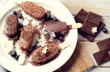Chocolate ice cream popsicles on white plate