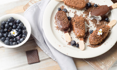 Chocolate ice cream popsicles on white plate