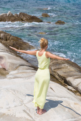 attractive woman practicing yoga by the beach