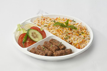 Indian meal combo with mutton Seekh kebab with biryani and daal mash  in disposable plate