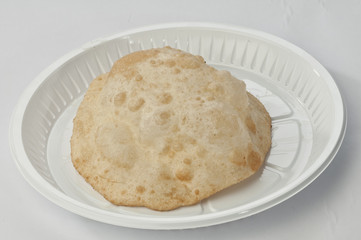 Puri on white disposable plate